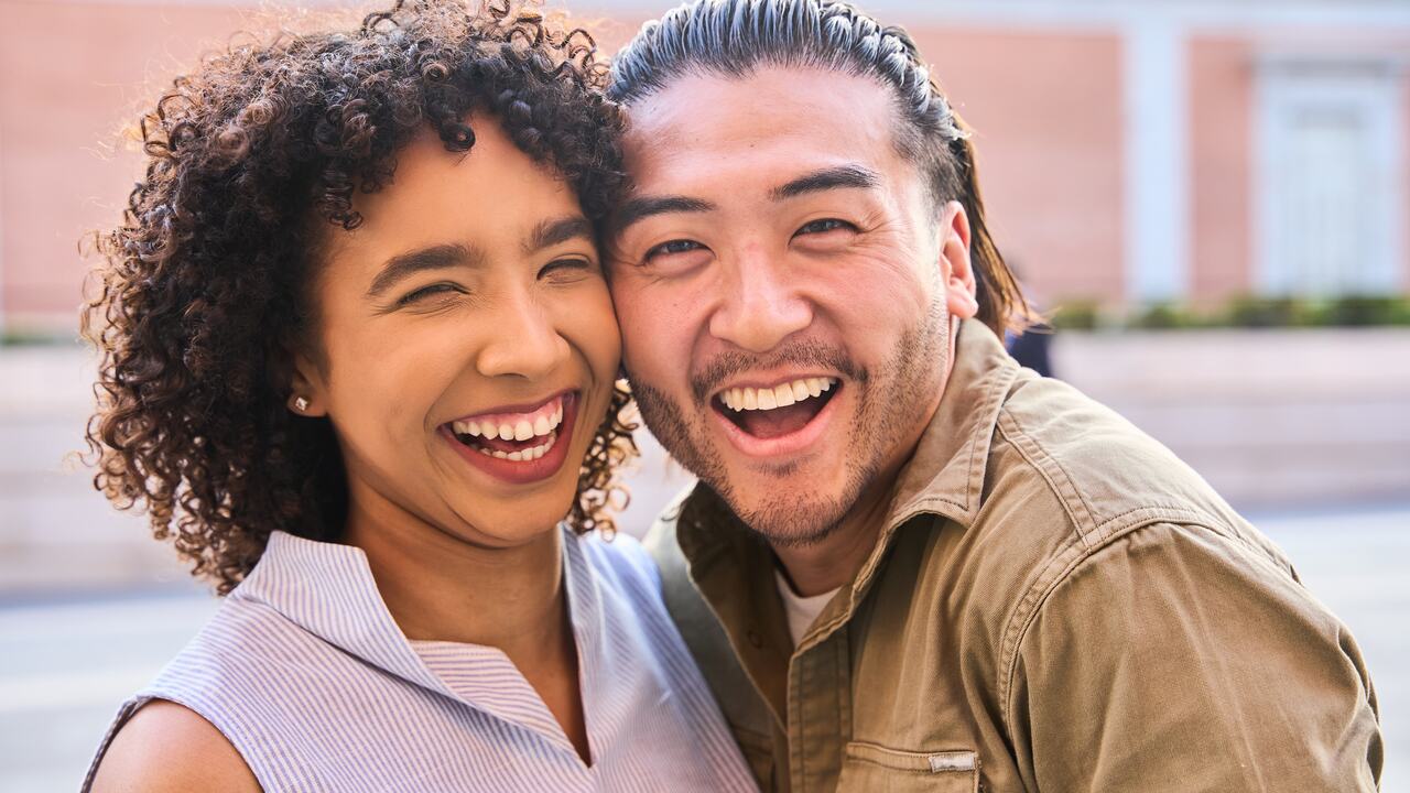 A couple laughing together in Los Angeles, framed in warm afternoon light.